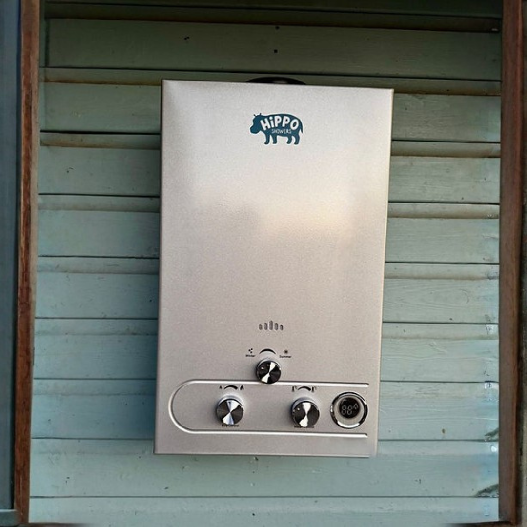 Metallic water heater with 'Hippo' branding on a wooden wall.