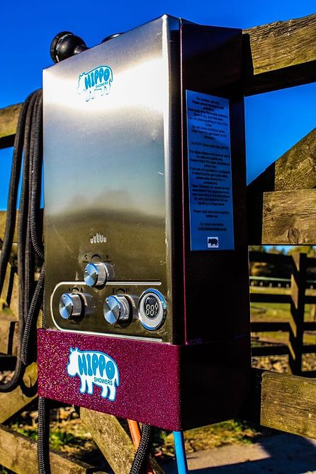 Metallic device with 'Hippo' branding attached to a wooden fence against a blue sky.