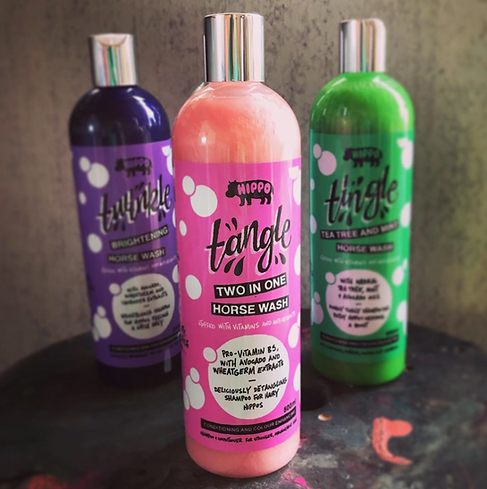 Three bottles of Hippo Tingle horse wash products on a surface with a neutral background.